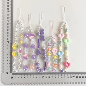 Detailed view of handmade macaron-colored beaded phone straps with cute acrylic charms