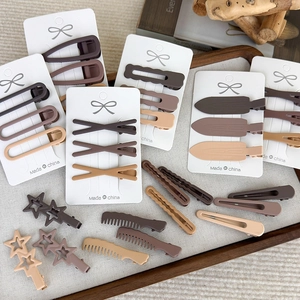 Brown seamless hair clips set with matte finish shapes on a white card display