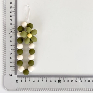 Size measurement of green beaded flower phone strap showing 11.5cm length with scale ruler