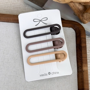 Close-up of matte coffee brown seamless hair clips set on elegant display card