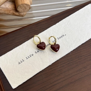 French retro gold earrings featuring dark red enamel heart pendants on a textured card