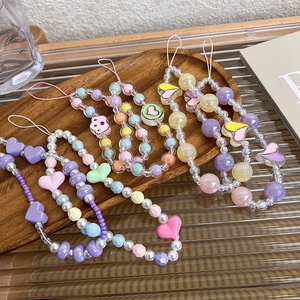 Handmade colorful macaron bead phone charms with heart and star pendants on tray