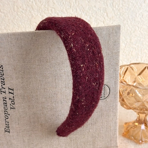 Close-up of vintage burgundy plush headband with golden glitters and thick knit texture