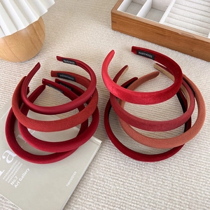 Detail showing various red velvet and satin headbands with handmade woven labels