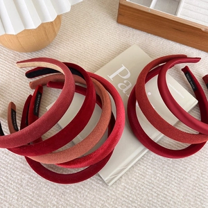 Detail showing various red velvet and knitted headbands with handmade label tags