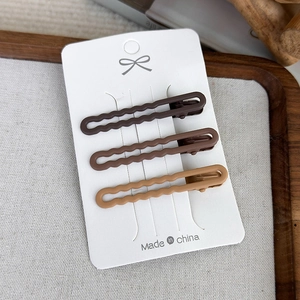 Three-piece set of matte earth-toned wave hair pins on white display card