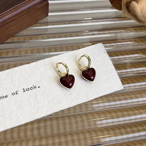 Close-up of French vintage gold hoop earrings with deep red enamel heart charms
