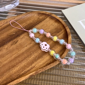 Detail of handmade pastel beaded phone wrist strap with pink cloud charm on wood tray