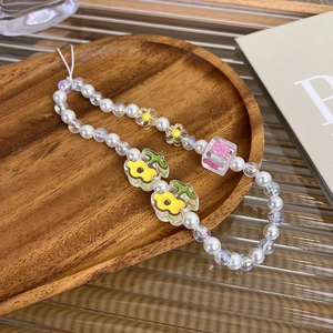 Detailed macro view of handmade candy-colored beaded phone lanyard with pearl and flower charms