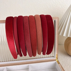 Close-up of eight red gradient fabric headbands displayed on a wooden glass storage box
