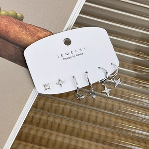 Detailed close-up of a 6-piece silver star and moon earring set with zircons on display card