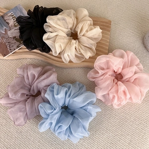 Elegant organza oversized hair scrunchies in five pastel colors on a wooden tray