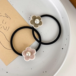 Vue détaillée de breloques fleurs en perles sur des élastiques à cheveux extensibles