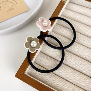 Deux chouchous à fleurs avec perles en rose et vert olive sur une boîte à bijoux