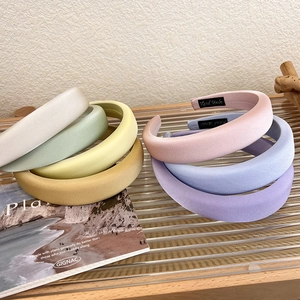 Detailed close-up of colorful satin sponge headbands with artisanal Hand Made labels