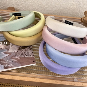 Detailed view of padded satin headbands in pastel colors with high crown sponge design