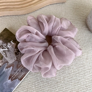 Detailed texture of a soft lavender organza scrunchie displayed on a decorative wooden tray