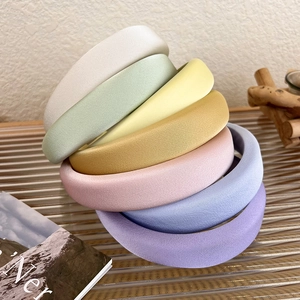 Close-up of colorful satin sponge headbands stacked to show thickness and soft matte texture