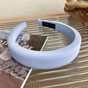 Detail of light blue satin sponge headband with fine texture on ribbed glass tray