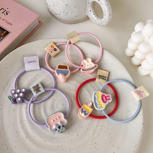 Détail d'élastiques à cheveux mignons avec lapins en résine sur une assiette chic