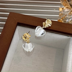 Detailed shot of French vintage gold rose stud earrings with transparent heart pendants