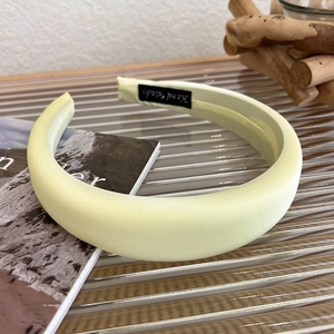 Detail of light yellow satin sponge headband with fine Hand Made inner label texture