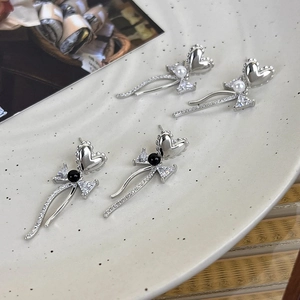 Elegant silver heart earrings with bow design, pearls, and sparkling zircon accents