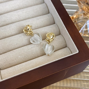 Detail of vintage French style gold rose stud earrings with frosted heart glass pendants