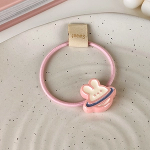 Détail d'un élastique rose avec lapin en résine et étiquette Sweet sur plateau chic