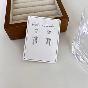 Detail of silver heart zircon stud earrings set on a white jewelry display card