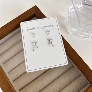Detailed view of silver heart zircon earring set including studs and drop earrings