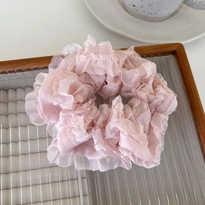 Detail shot of light pink pleated mesh scrunchie with soft ruffled organza texture
