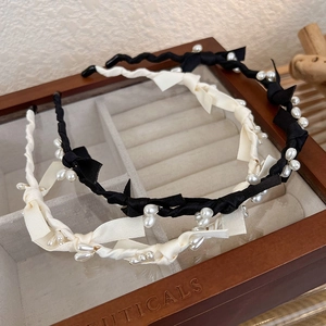 Serre-tête élégant en satin avec nœud et perles noires et beige, vue à 45 degrés