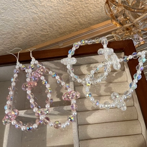 Colorful crystal pearl phone chain with pink beads and bow charms in jewelry box