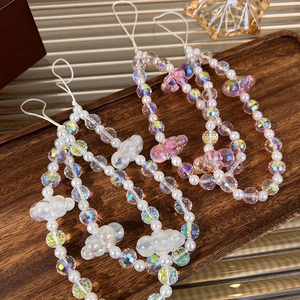 Colorful beaded phone charm with crystal pearls and bear pendant on a wooden tray