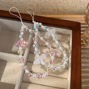 Close-up of colorful crystal bead phone charms with bear pendants in a jewelry box