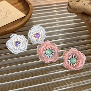 Sweet mesh flower earrings with crystal center on a textured glass tray display
