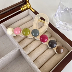 Detail showing the colorful bead decorations and champagne resin of this hair claw clip