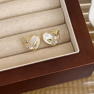 Elegantes pendientes de corazón y tulipa dorada con nácar en joyero de madera decorativo