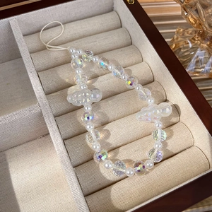 Detailed macro view of colorful crystal beads and cloud charms in a wooden jewelry box