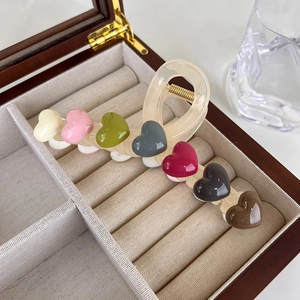 Macro detail of high-quality resin hair claw with seven colorful 3D heart shapes