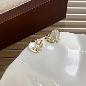Pendientes de corazón dorados con nácar iridiscente y un pequeño detalle de flor de rosa