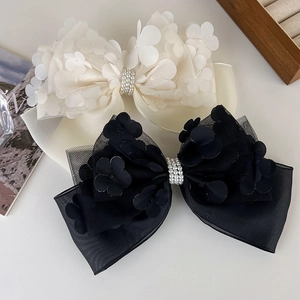 Détail de barrettes à fleurs en maille avec perles en blanc crème et noir classique