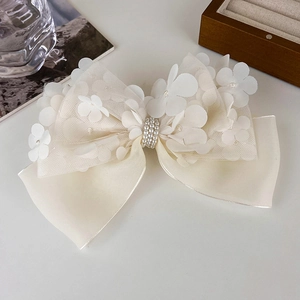 Détails de la pince à cheveux avec nœud en dentelle blanche et perles élégantes au centre