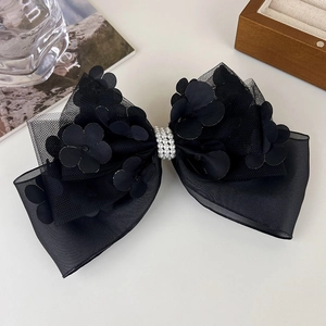 Détail du nœud à cheveux en dentelle noire avec fleurs 3D et rangées de perles fines
