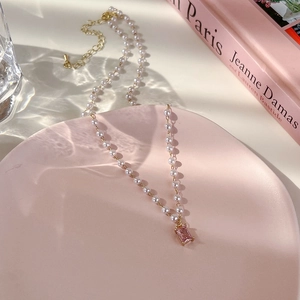 Détail du pendentif tulipe en zircon rose sur un collier élégant en perles