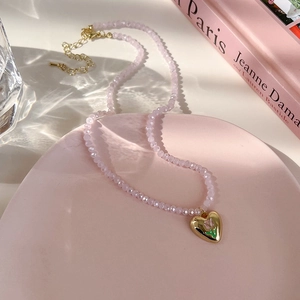 Gros plan du collier de perles tulipe rose sur une assiette décorative rose