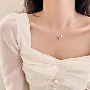 Collana a cuore in argento con zircone viola mostrata sul collo di una modella