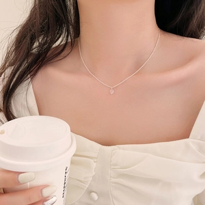 Collier minimaliste en argent avec pendentif cœur en cristal rose porté par un mannequin