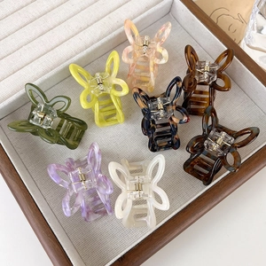 Set of colorful acetate butterfly hair claws in pastel tones on a wooden tray